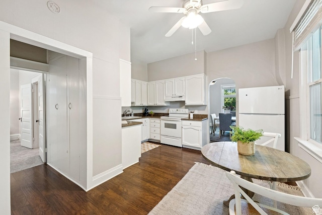 921 E 800 S, Salt Lake City, UT 84102 - kitchen with white appliances, arched walkways, under cabinet range hood, white cabinetry, and dark wood-style flooring