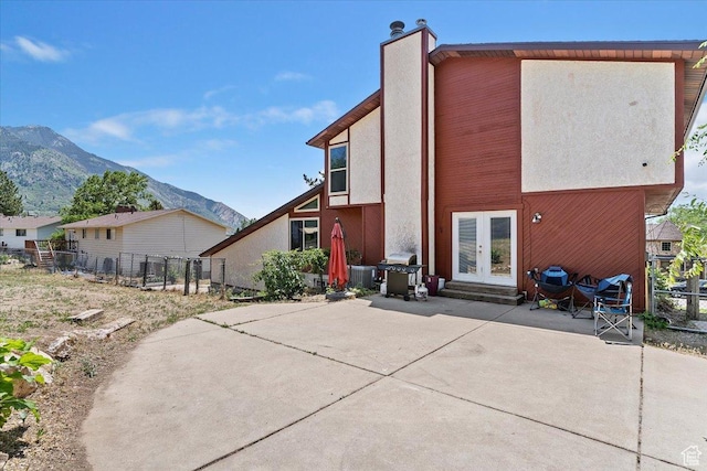1260 E 2925 N, North Ogden, UT 84414 - back of property featuring french doors, a patio area, a mountain view, and stucco siding
