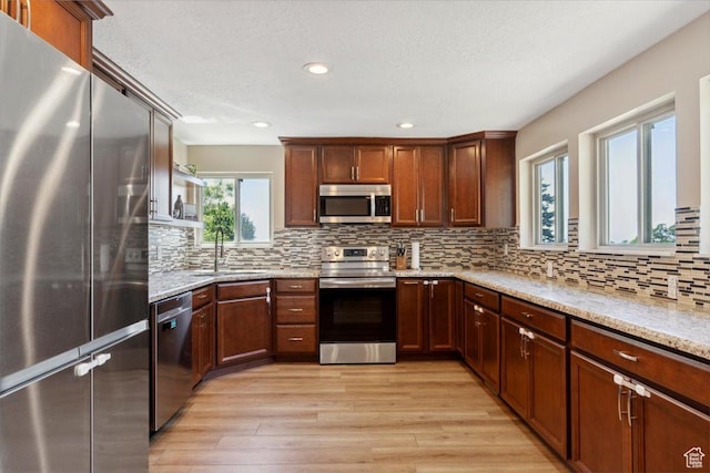 1260 E 2925 N, North Ogden, UT 84414 - kitchen with appliances with stainless steel finishes, light wood-style flooring, light stone counters, backsplash, and recessed lighting