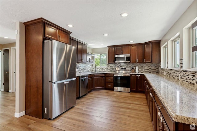 1260 E 2925 N, North Ogden, UT 84414 - kitchen featuring appliances with stainless steel finishes, light stone counters, light wood-style floors, recessed lighting, and tasteful backsplash