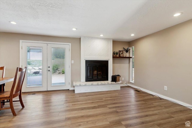 1260 E 2925 N, North Ogden, UT 84414 - unfurnished living room featuring french doors, wood finished floors, recessed lighting, a fireplace, and a textured ceiling