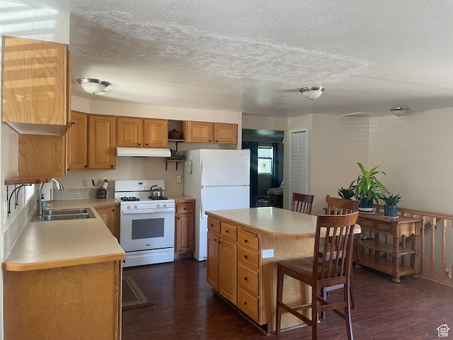 395 E Center St, Spring City, UT 84662 - kitchen with white appliances, dark wood-style flooring, light countertops, a center island, and a breakfast bar area