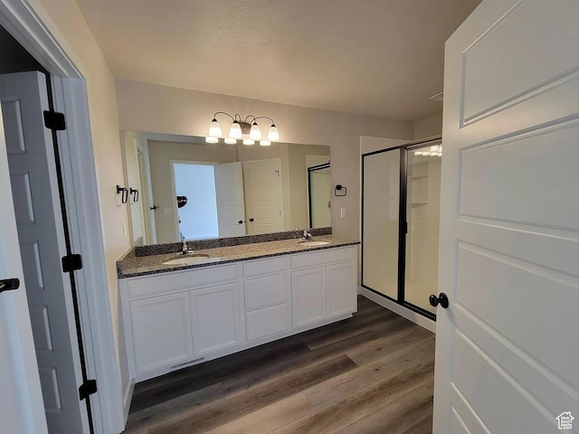 15040 S Wild Horse Way, Bluffdale, UT 84065 - bathroom with wood finished floors, double vanity, a shower stall, and a chandelier