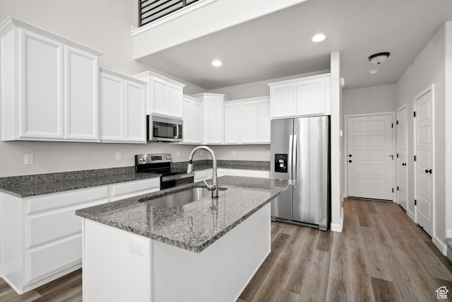 15040 S Wild Horse Way, Bluffdale, UT 84065 - kitchen with appliances with stainless steel finishes, wood finished floors, white cabinetry, dark stone counters, and recessed lighting