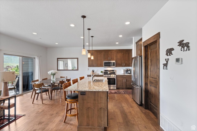 1076 W Abigail Dr, Kamas, UT 84036 - kitchen featuring stainless steel appliances, recessed lighting, dark wood-type flooring, a center island with sink, and a breakfast bar