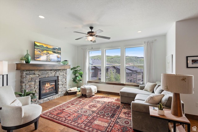 1076 W Abigail Dr, Kamas, UT 84036 - living area with ceiling fan, a stone fireplace, wood finished floors, and recessed lighting