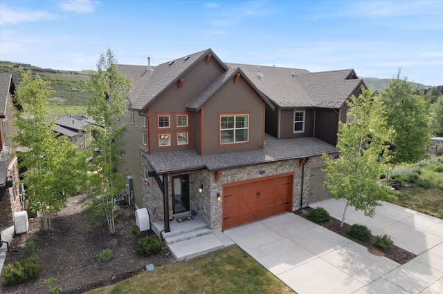 1076 W Abigail Dr, Kamas, UT 84036 - view of front of house featuring stone siding, concrete driveway, a garage, and a shingled roof