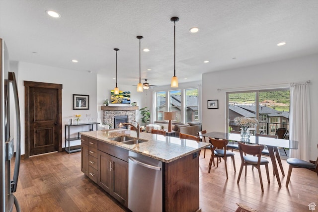 1076 W Abigail Dr, Kamas, UT 84036 - kitchen with appliances with stainless steel finishes, a fireplace, dark wood-type flooring, a ceiling fan, and decorative light fixtures