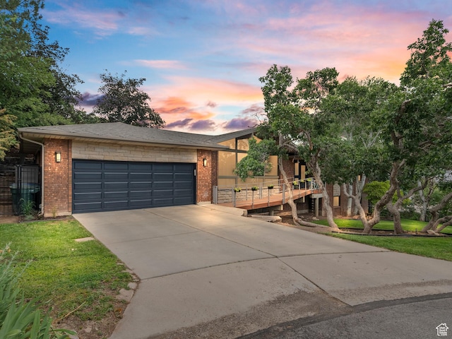 2842 E Oakbrook Cir, Salt Lake City, UT 84108 - view of front facade featuring brick siding, driveway, an attached garage, and a front lawn