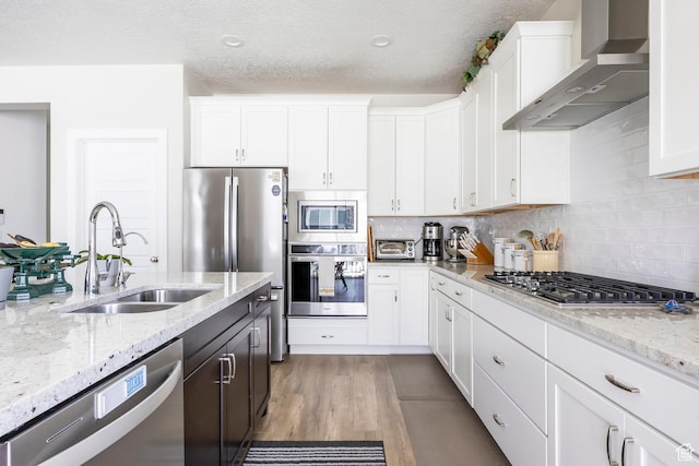 1681 S 1110 E, Heber City, UT 84032 - kitchen featuring wall chimney range hood, appliances with stainless steel finishes, white cabinets, decorative backsplash, and light stone countertops