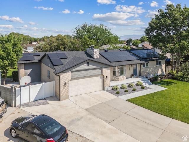 2104 W Champagne Cir, Taylorsville, UT 84129 - ranch-style house with brick siding, a garage, solar panels, concrete driveway, and a shingled roof