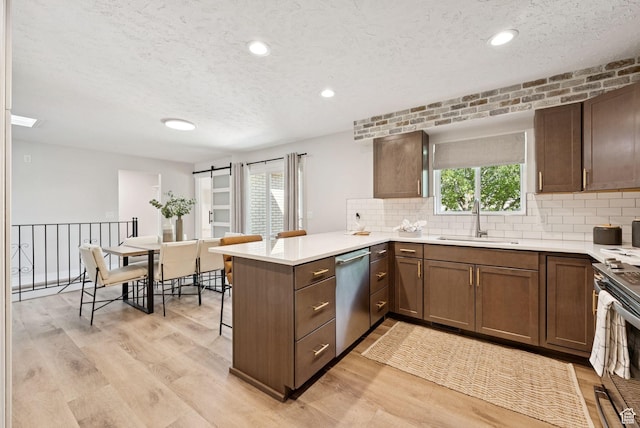 2104 W Champagne Cir, Taylorsville, UT 84129 - kitchen with dishwasher, a peninsula, light wood-style flooring, a textured ceiling, and gas range oven