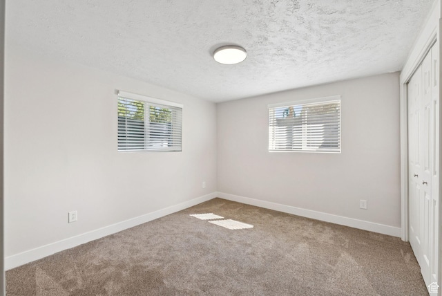 2104 W Champagne Cir, Taylorsville, UT 84129 - unfurnished bedroom with a closet, carpet flooring, and a textured ceiling
