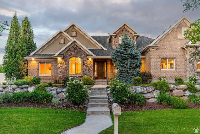 10677 S Amberley Ln E, Sandy, UT 84094 - view of front of home featuring a front yard, stone siding, stucco siding, brick siding, and roof with shingles
