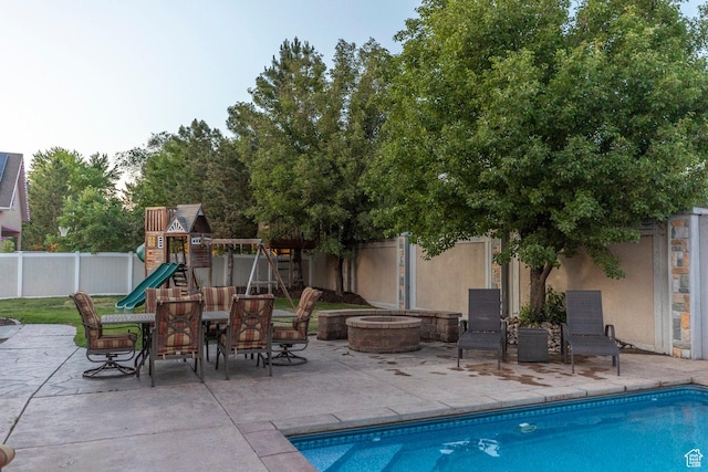 10677 S Amberley Ln E, Sandy, UT 84094 - view of swimming pool featuring a playground, an outdoor fire pit, a fenced backyard, and a patio
