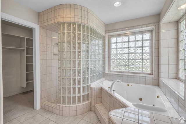 1912 W Rivers Edge Ln, St George, UT 84770 - bathroom featuring a jetted tub, tile patterned flooring, walk in shower, a walk in closet, and tile walls