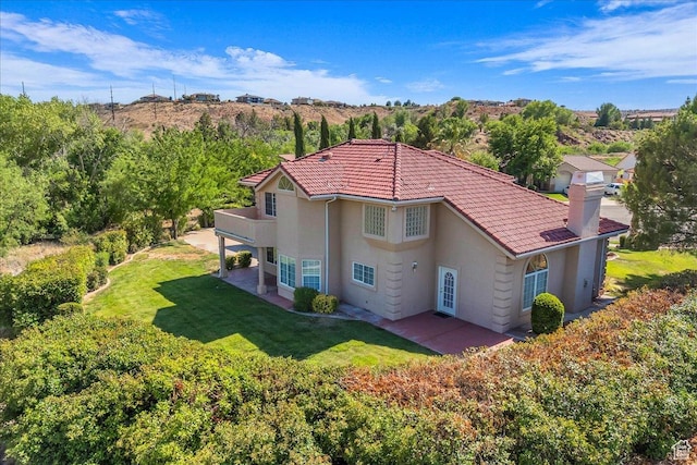 1912 W Rivers Edge Ln, St George, UT 84770 - back of property featuring a yard, a chimney, a patio area, stucco siding, and a tile roof