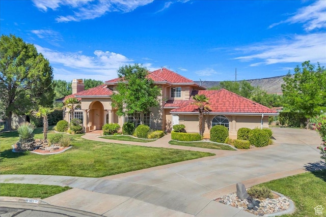1912 W Rivers Edge Ln, St George, UT 84770 - mediterranean / spanish home with stucco siding, a tiled roof, a front yard, and a chimney