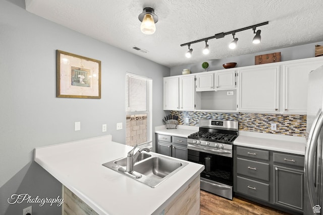 1161 S 860 W, Cedar City, UT 84720 - kitchen with stainless steel appliances, wood finished floors, gray cabinetry, a peninsula, and a textured ceiling
