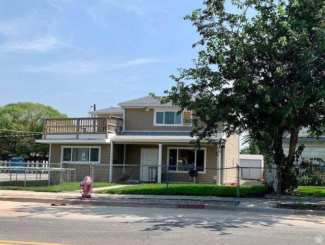7805 S Main St, Midvale, UT 84047 - view of front of house with a balcony, a fenced front yard, and a porch