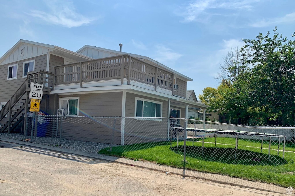 7805 S Main St, Midvale, UT 84047 - view of side of home featuring a balcony, a fenced front yard, and board and batten siding