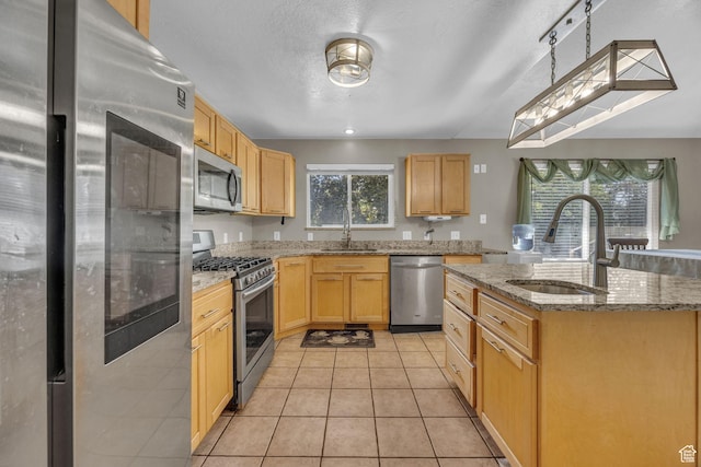 2352 N 1160 W, Clinton, UT 84015 - kitchen featuring stainless steel appliances, light brown cabinetry, a center island with sink, light tile patterned floors, and light stone counters