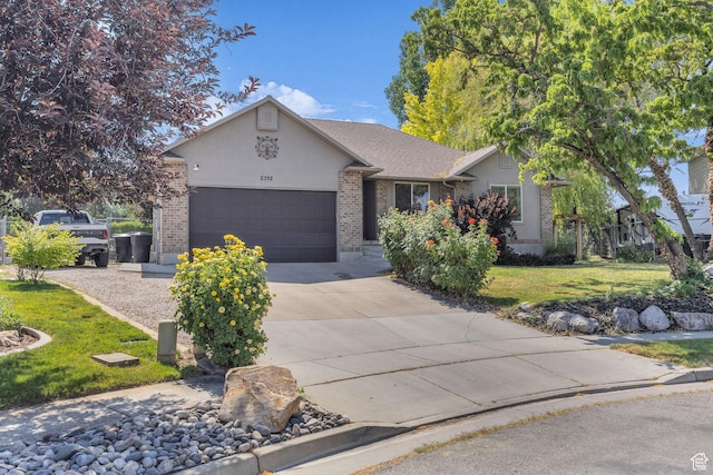 2352 N 1160 W, Clinton, UT 84015 - single story home with brick siding, driveway, an attached garage, a front yard, and stucco siding