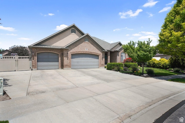 3116 W Hayden Ridge Way, Riverton, UT 84065 - view of front of property with brick siding, a garage, driveway, a gate, and stucco siding