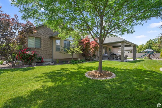 3116 W Hayden Ridge Way, Riverton, UT 84065 - rear view of house featuring a playground, a patio area, and brick siding