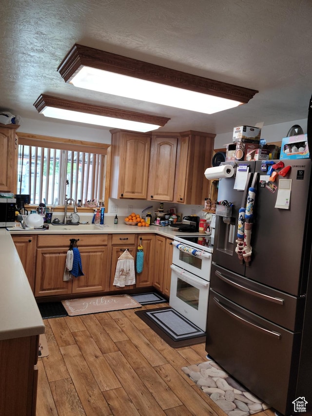 97 Main St, Ophir, UT 84071 - kitchen featuring appliances with stainless steel finishes, light wood-style floors, light countertops, and a textured ceiling