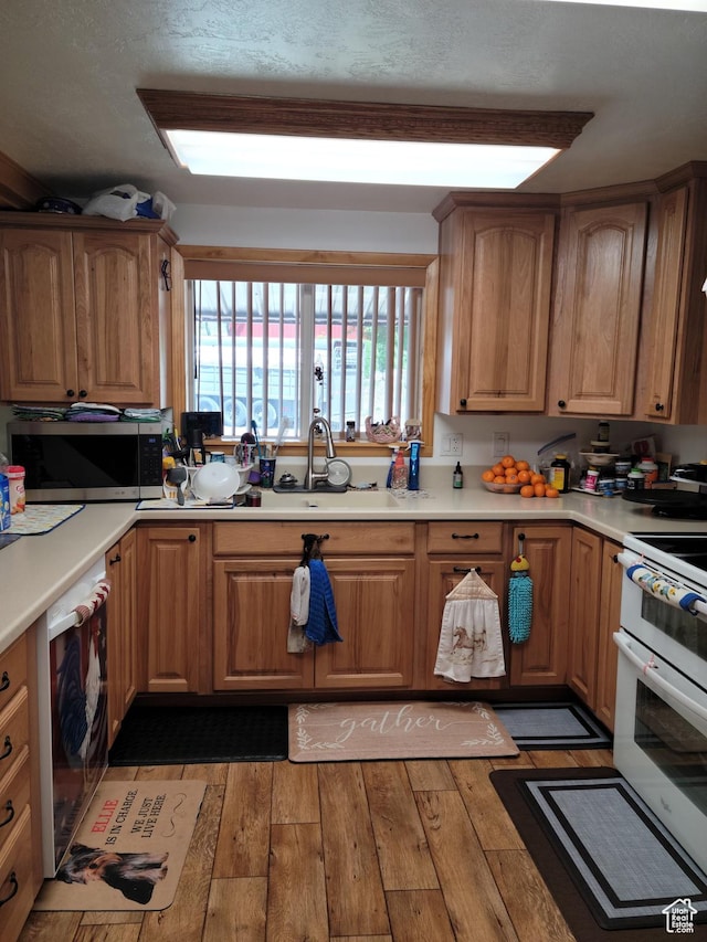 97 Main St, Ophir, UT 84071 - kitchen featuring stainless steel microwave, double oven range, light wood-type flooring, and light countertops