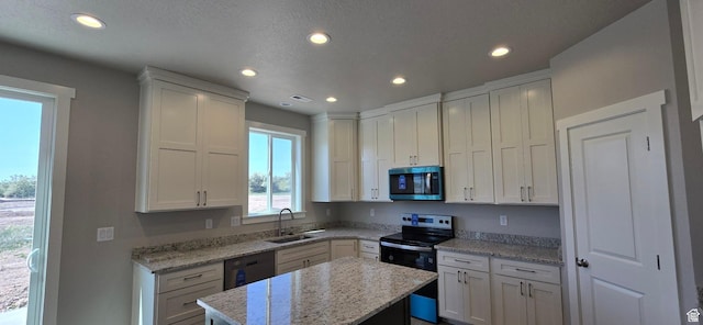 201 W 1300 S, Tremonton, UT 84337 - kitchen featuring appliances with stainless steel finishes, recessed lighting, white cabinetry, a kitchen island, and light stone counters