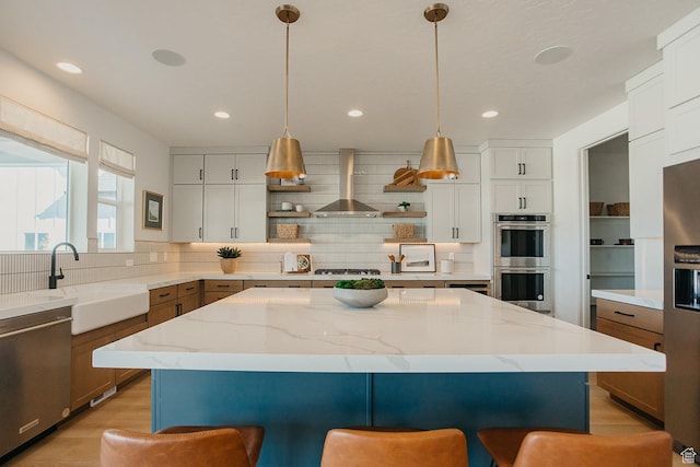 3488 E 1120 S Unit 115, Spanish Fork, UT 84660 - kitchen featuring appliances with stainless steel finishes, wall chimney range hood, open shelves, a breakfast bar, and tasteful backsplash