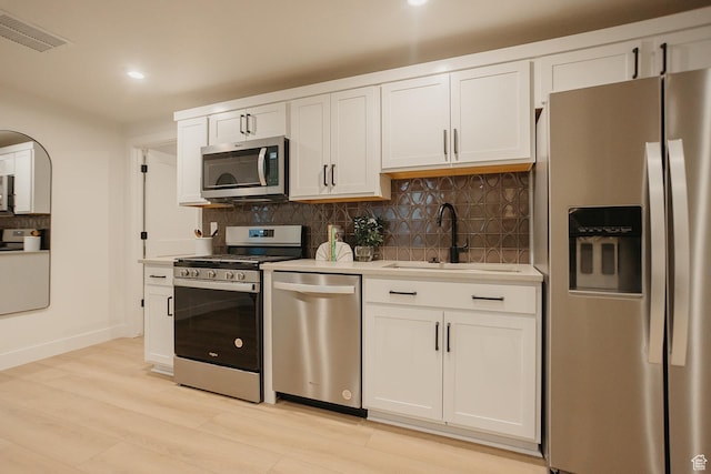 3488 E 1120 S Unit 115, Spanish Fork, UT 84660 - kitchen featuring stainless steel appliances, light countertops, tasteful backsplash, white cabinetry, and light wood-style floors