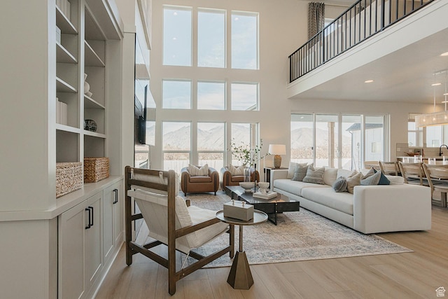 3488 E 1120 S Unit 115, Spanish Fork, UT 84660 - living area with a towering ceiling, light wood-type flooring, and a mountain view