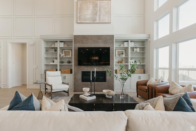 3488 E 1120 S Unit 115, Spanish Fork, UT 84660 - living room featuring a fireplace, a decorative wall, a towering ceiling, and wood finished floors