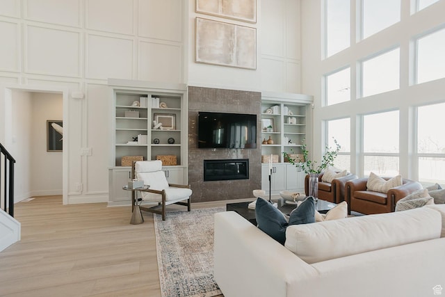 3488 E 1120 S Unit 115, Spanish Fork, UT 84660 - living area with a towering ceiling, a decorative wall, a high end fireplace, and light wood-style floors