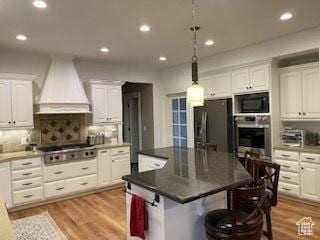 70 W 1790 N, Genola, UT 84655 - kitchen with premium range hood, appliances with stainless steel finishes, white cabinetry, a kitchen bar, and recessed lighting