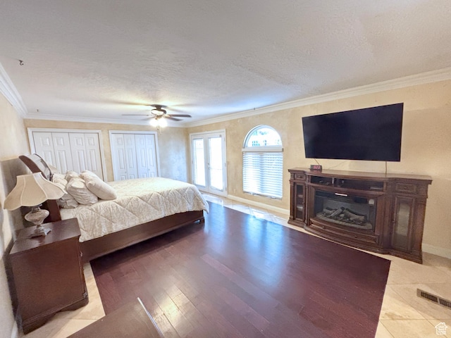 289 W Count Fleet Rd, St George, UT 84790 - bedroom featuring two closets, ornamental molding, a textured ceiling, wood finished floors, and a ceiling fan