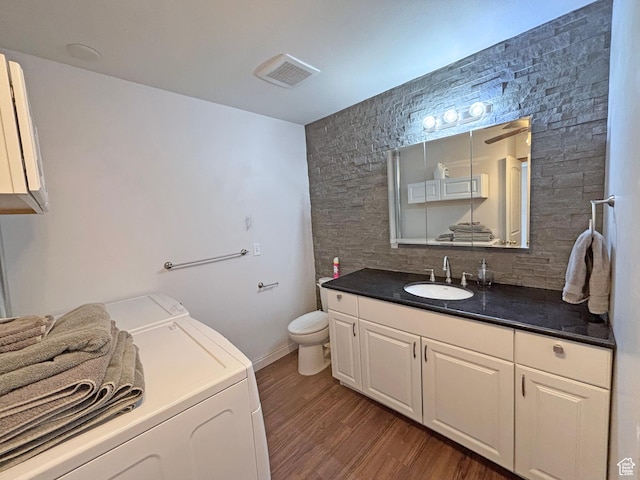 289 W Count Fleet Rd, St George, UT 84790 - bathroom featuring washer and dryer, vanity, wood finished floors, and tasteful backsplash