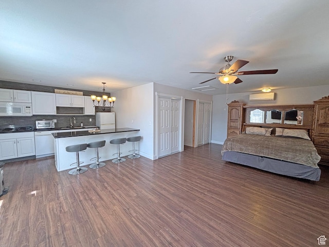 289 W Count Fleet Rd, St George, UT 84790 - kitchen with white appliances, dark countertops, a breakfast bar, open floor plan, and ceiling fan