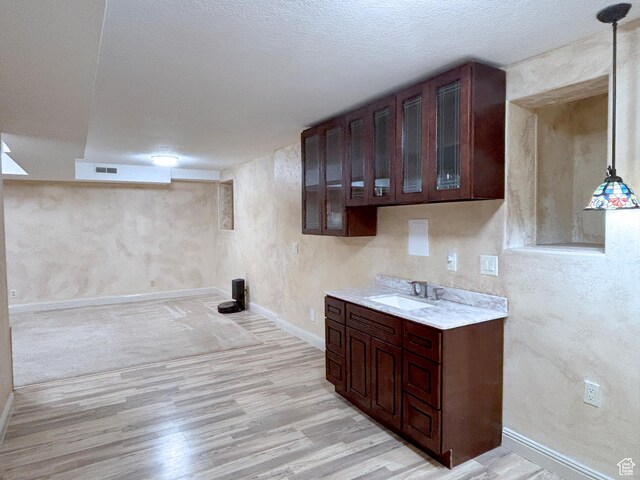 289 W Count Fleet Rd, St George, UT 84790 - kitchen featuring light wood-type flooring, light countertops, dark brown cabinets, and glass insert cabinets