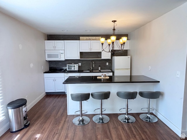 289 W Count Fleet Rd, St George, UT 84790 - kitchen featuring white appliances, a chandelier, a kitchen bar, and dark countertops