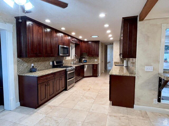 289 W Count Fleet Rd, St George, UT 84790 - kitchen with appliances with stainless steel finishes, tasteful backsplash, recessed lighting, light stone countertops, and dark brown cabinets