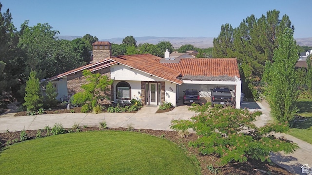 289 W Count Fleet Rd, St George, UT 84790 - mediterranean / spanish-style house with a chimney, concrete driveway, stucco siding, and a front yard
