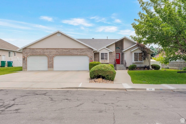 335 W 1410 S, Orem, UT 84058 - view of front of house with a front lawn, an attached garage, driveway, brick siding, and stucco siding