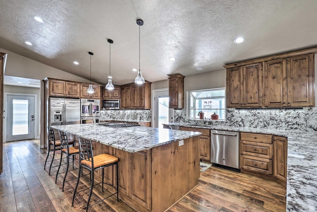 3572 Wild Mare Way, Heber City, UT 84032 - kitchen featuring stainless steel appliances, a textured ceiling, a center island, decorative backsplash, and hardwood / wood-style floors