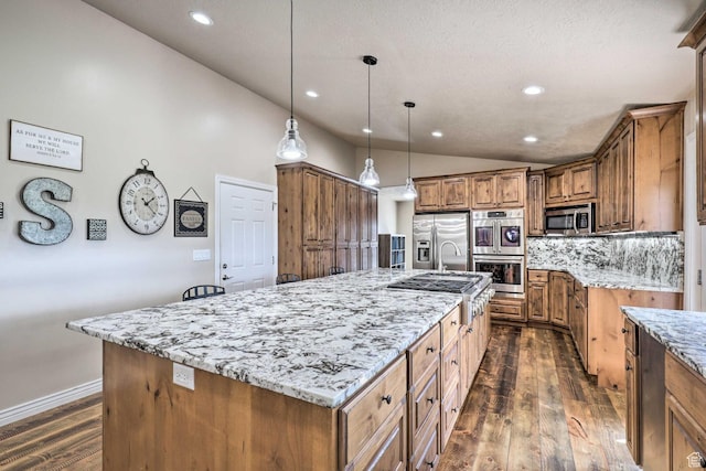3572 Wild Mare Way, Heber City, UT 84032 - kitchen with stainless steel appliances, lofted ceiling, brown cabinetry, dark wood-style floors, and a large island