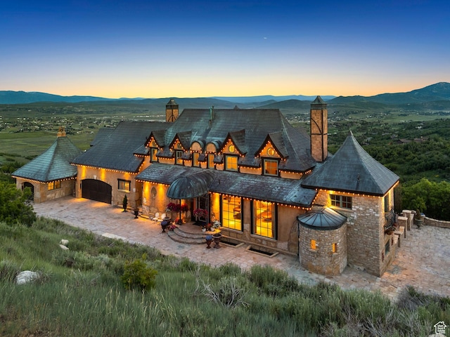 1526 W Red Hawk Trl, Park City, UT 84098 - back of house with a chimney, a mountain view, a garage, and stone siding