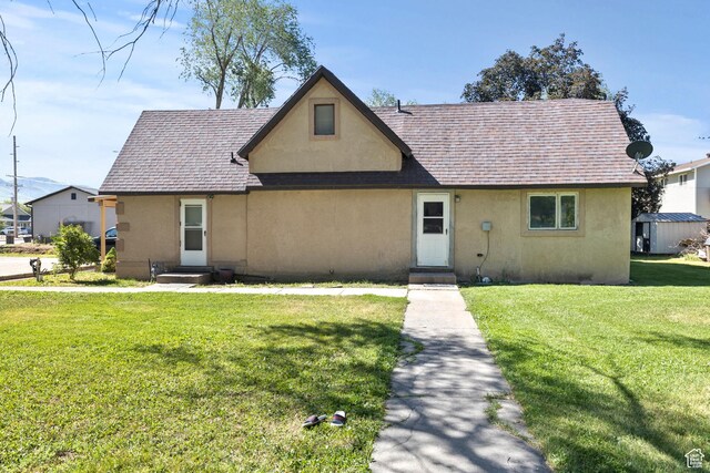 165 N 800 E, Hyrum, UT 84319 - tudor-style house with stucco siding, a front lawn, and a shingled roof